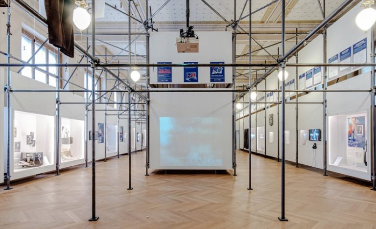  VÝSTAVA SAMETOVÁ REVOLUCE V HISTORICKÉ BUDOVĚ NÁRODNÍHO MUZEA / Realizace expozice k 30.výročí Sametové revoluce v rastru lešenářské konstrukce, která se tak často objevovala na neudžovaných domech v předlistopadovém období.