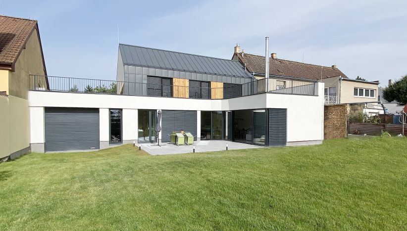  RODINNÝ DŮM NA NÁVSI/ Návrh rodinného domku, který je součástí uliční linie tvořenou převážně dvoupodlažními stavbami. Architektonické řešení vychází z půdorysné stopy zbouraného objektu ve tvaru písmene L. Objekt je rozdělen na dvě části a to podnož, obsahující průjezdnou garáž a obytné prostory otevřené do zahrady a vrchní část s pokoji a střešní terasou.